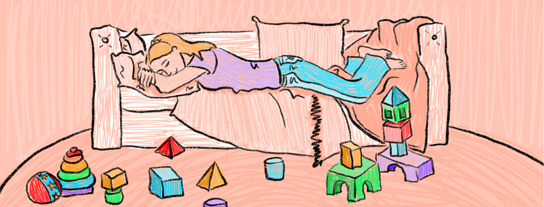 A woman lies on the couch, comfortably, with scattered building blocks on the carpet around her.