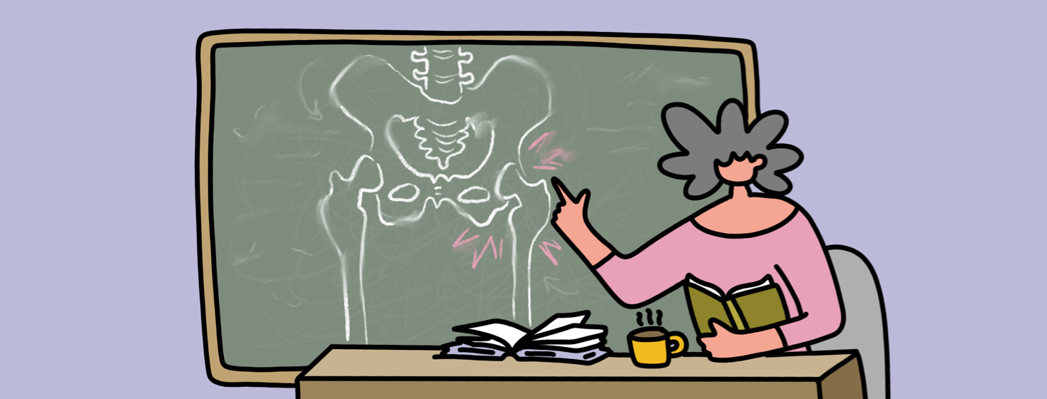 A woman sitting behind a teacher's desk, pointing to the chalkboard behind her which shows a drawing of an anatomical hip.