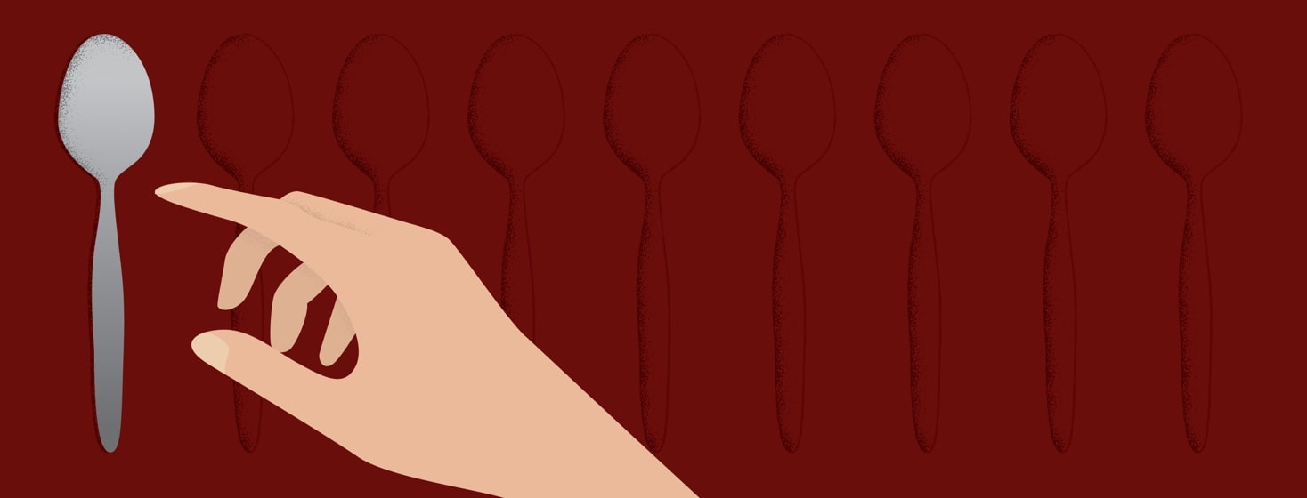 a person reaching to pick up the last spoon in a row